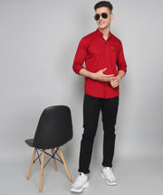 a man in a red shirt standing next to a chair