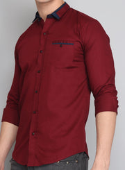 a man wearing a red shirt and jeans