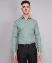 a man wearing a green shirt and black pants