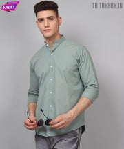 a man in a green shirt is holding a pair of headphones