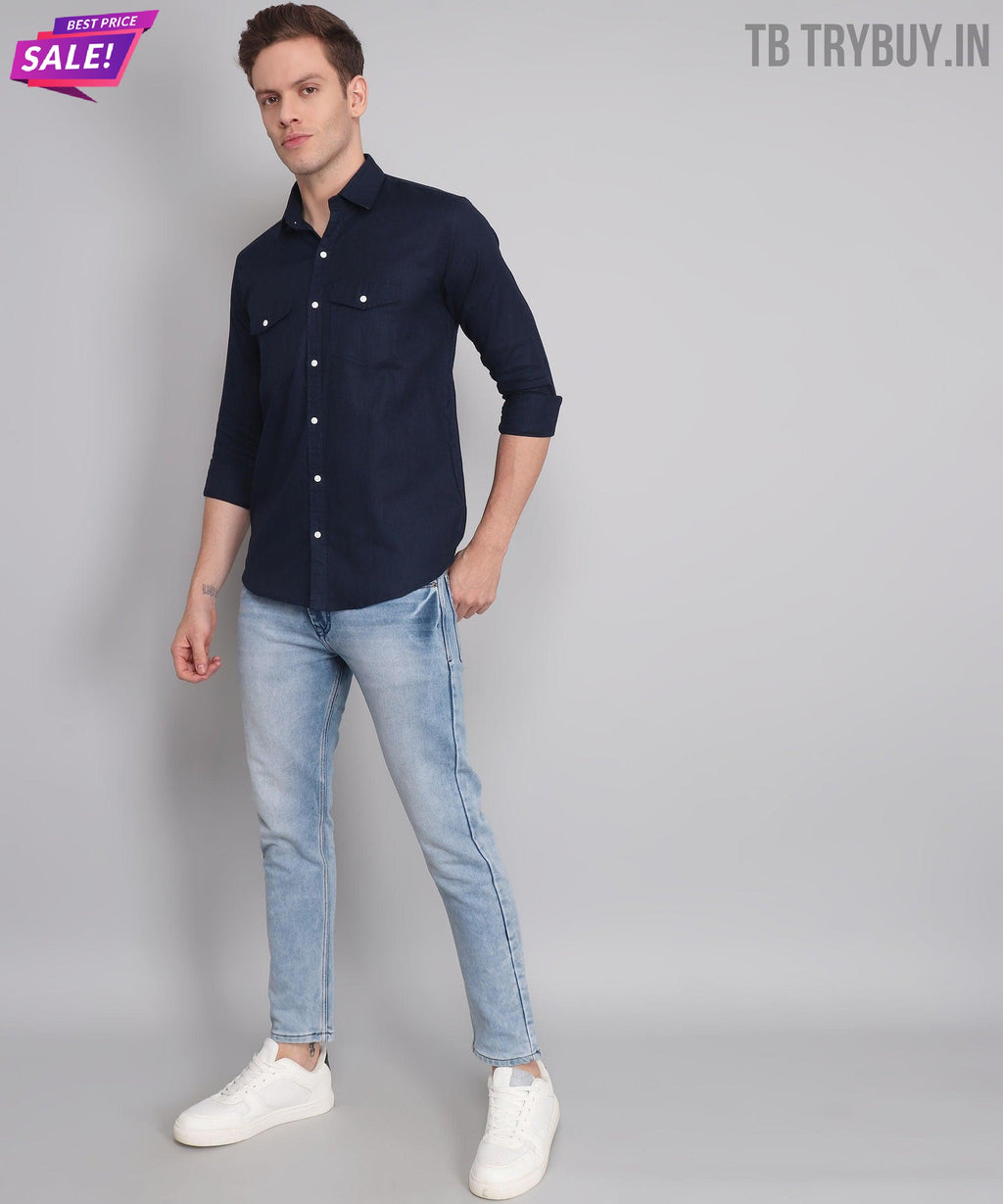 a man in a blue shirt and jeans posing for a picture