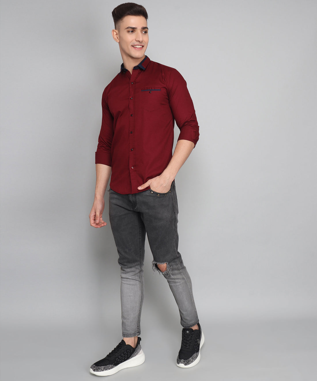 a young man in a red shirt and jeans
