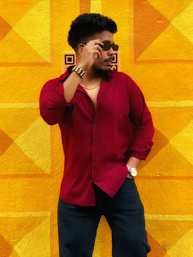 a man standing in front of a yellow wall talking on a cell phone