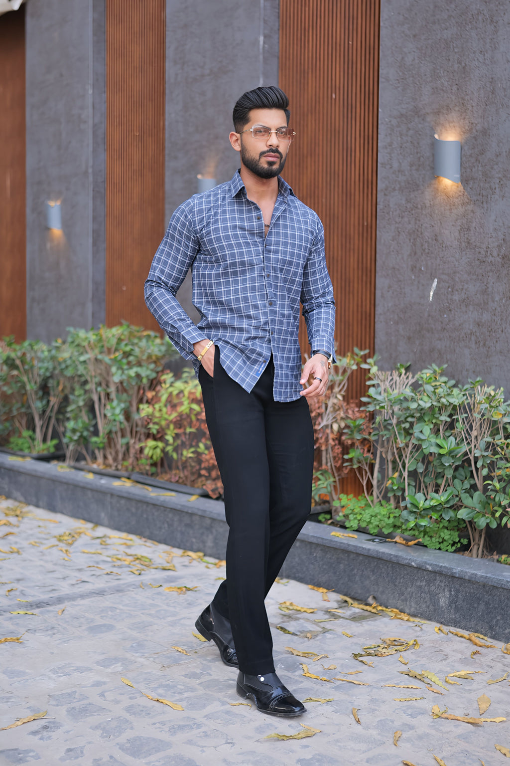 a man standing on a sidewalk in front of a building
