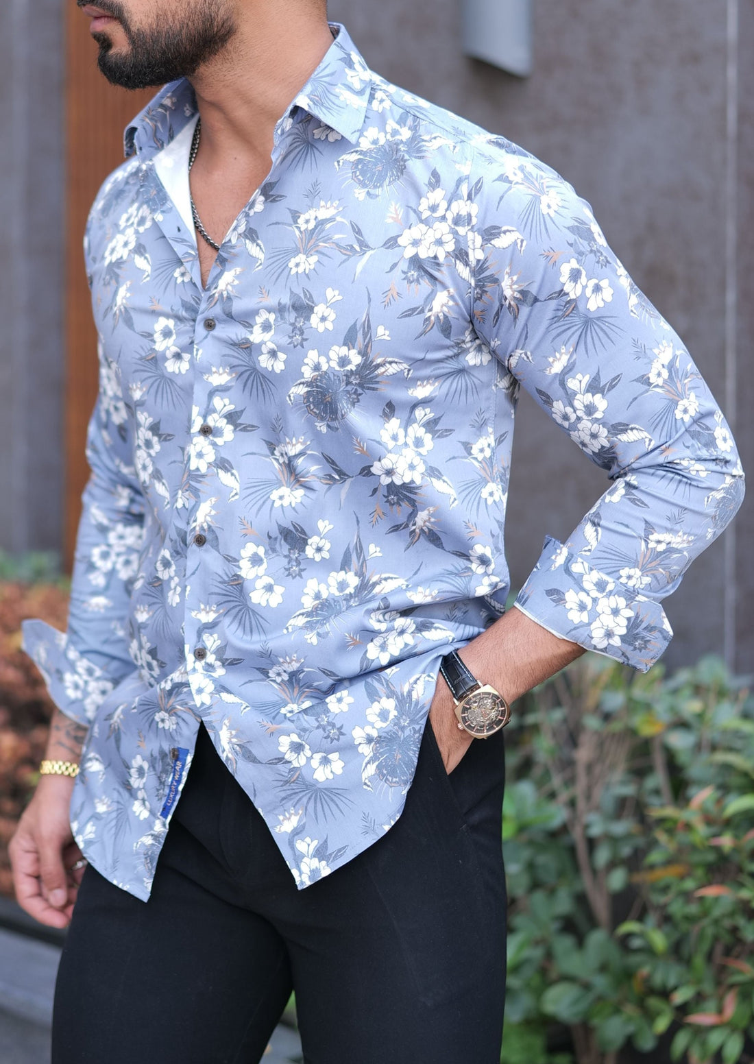 a man wearing a blue shirt and black pants