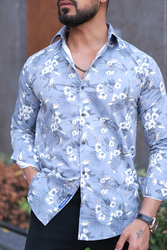 a man wearing a blue shirt with white flowers on it