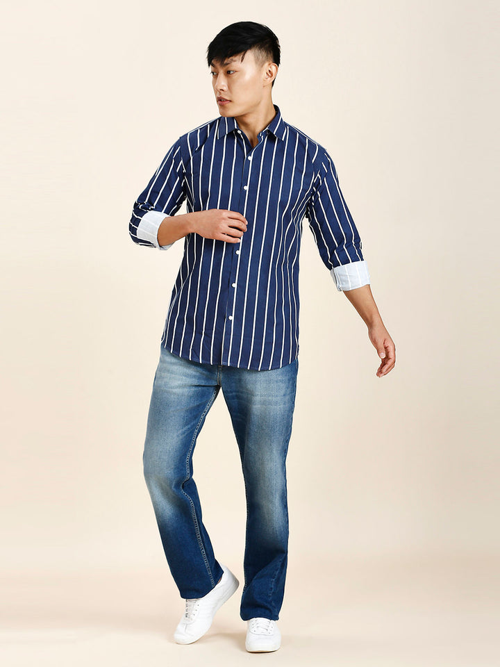 a man in a blue striped shirt and jeans