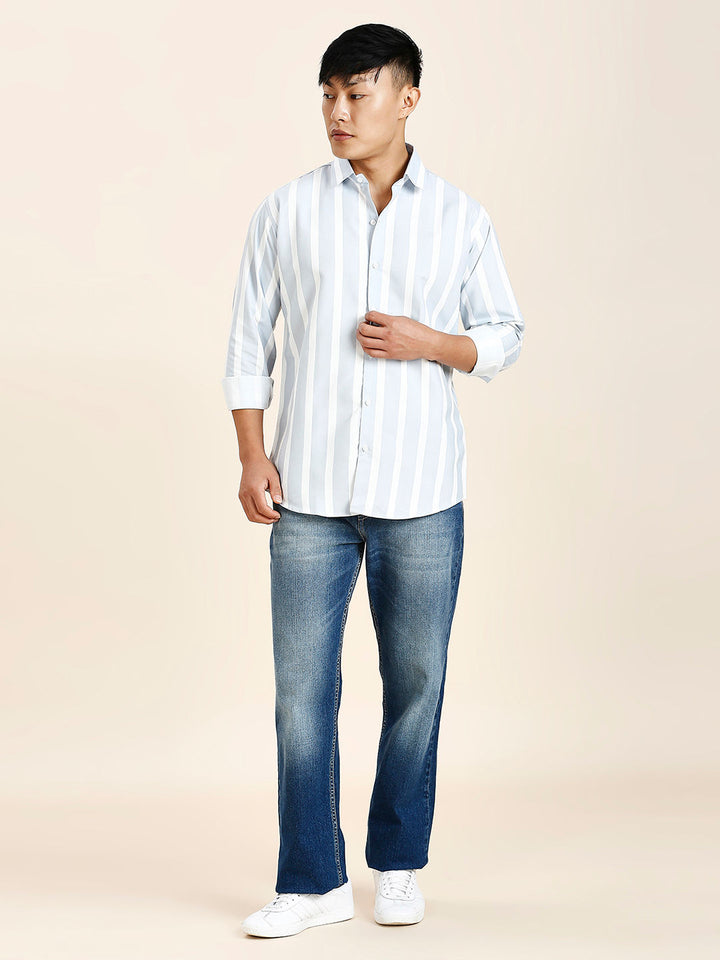 a man in a white shirt and blue jeans