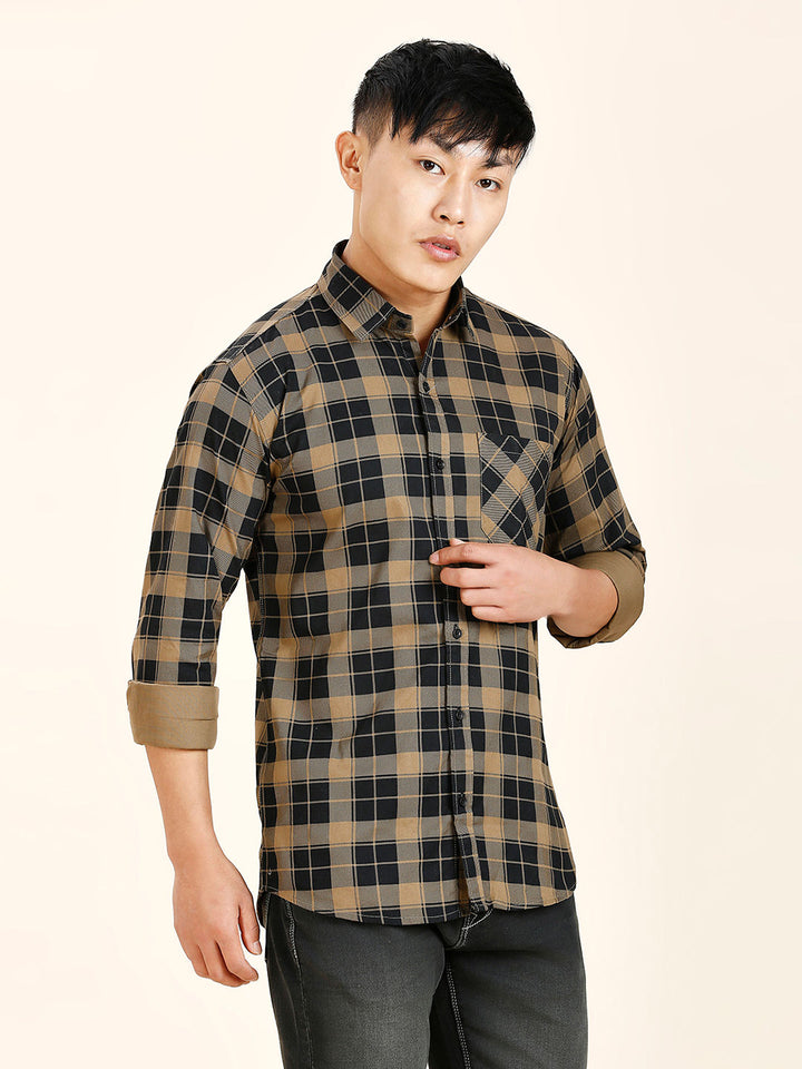 a man in a plaid shirt poses for a picture