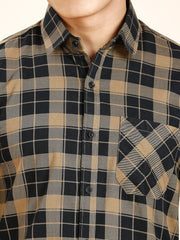 a man wearing a black and tan plaid shirt