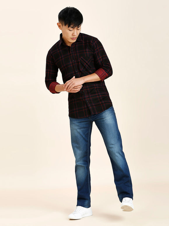 a man in a black and red shirt and jeans