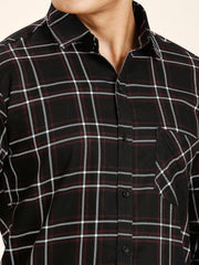 a man wearing a black and red plaid shirt