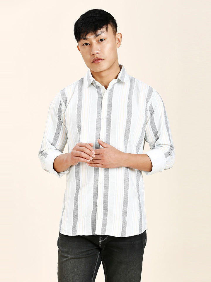 a young man in a striped shirt poses for a picture