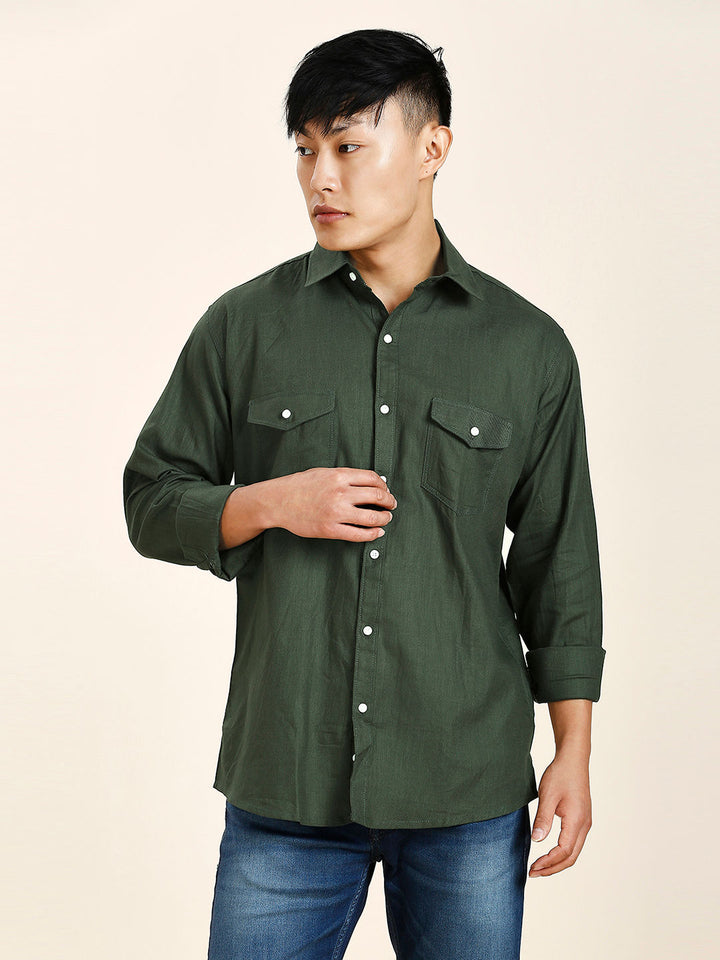 a man wearing a green shirt and jeans