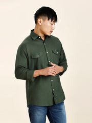 a man in a green shirt is posing for a picture