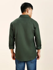 a man in a green shirt is looking away from the camera