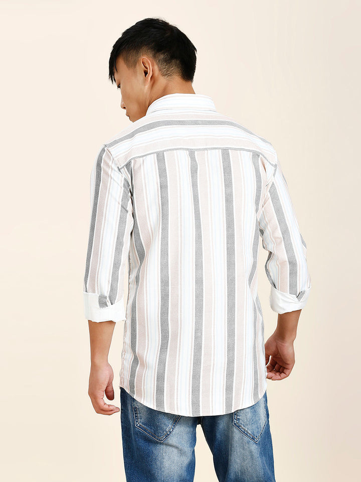 a man wearing a striped shirt and jeans