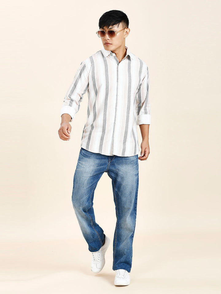 a young man in a striped shirt and jeans