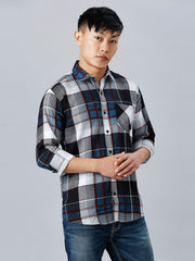 a man in a plaid shirt poses for a picture