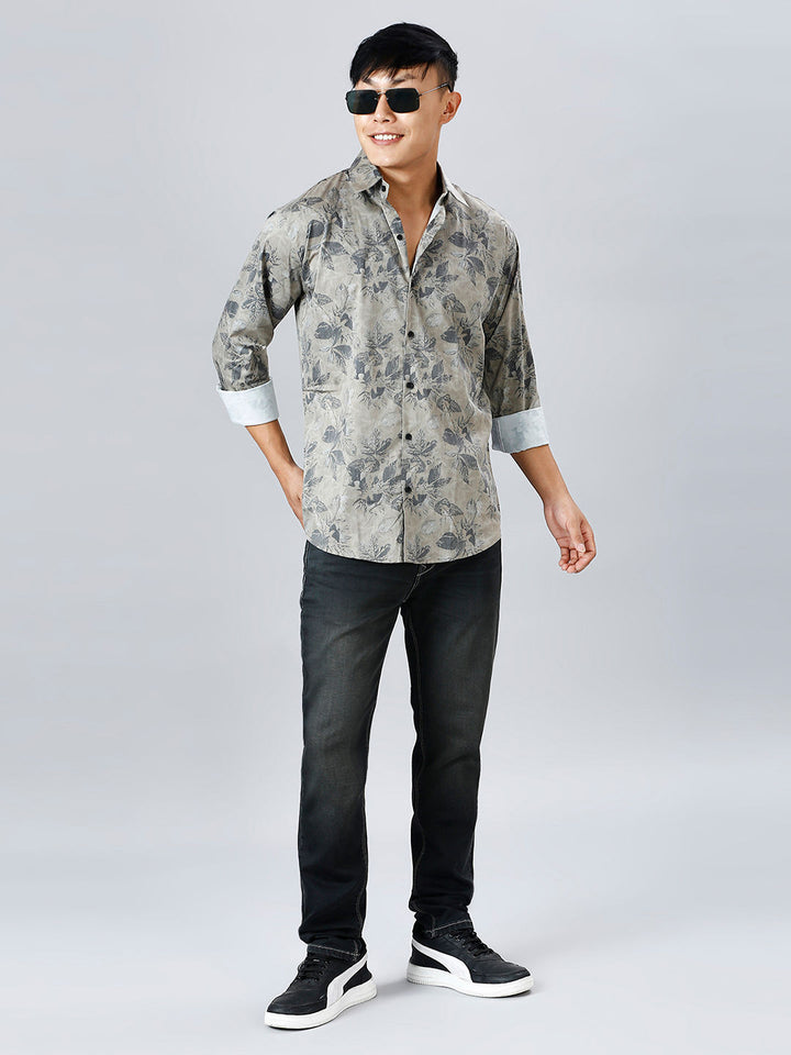 a young man in a shirt and jeans poses for a picture