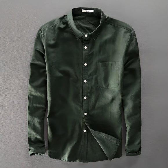 a green shirt hanging up against a wall
