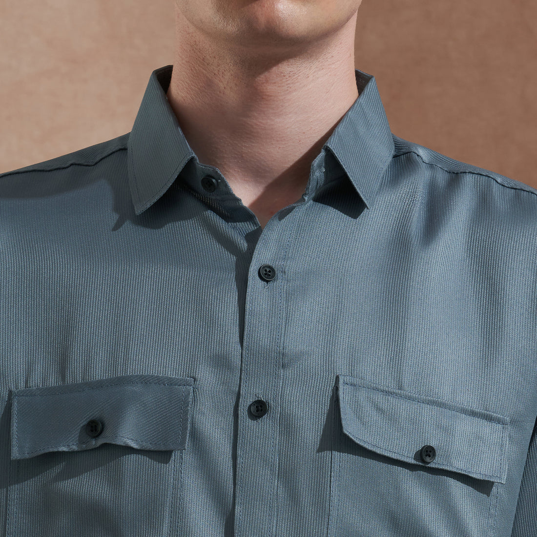 Men's blue solid slim-fit shirt with dual flap pockets, product view