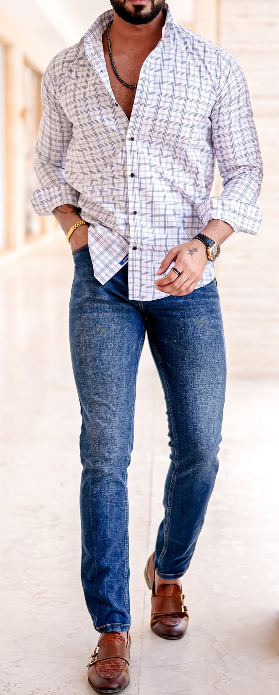 a man standing in a hallway with his hands in his pockets