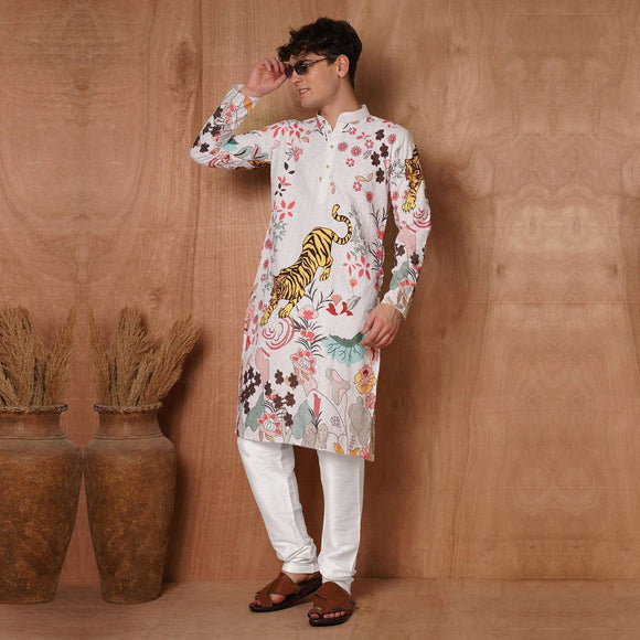 Model wearing men's white designer kurta with tiger and floral prints, paired with white pants for festive ethnic attire.