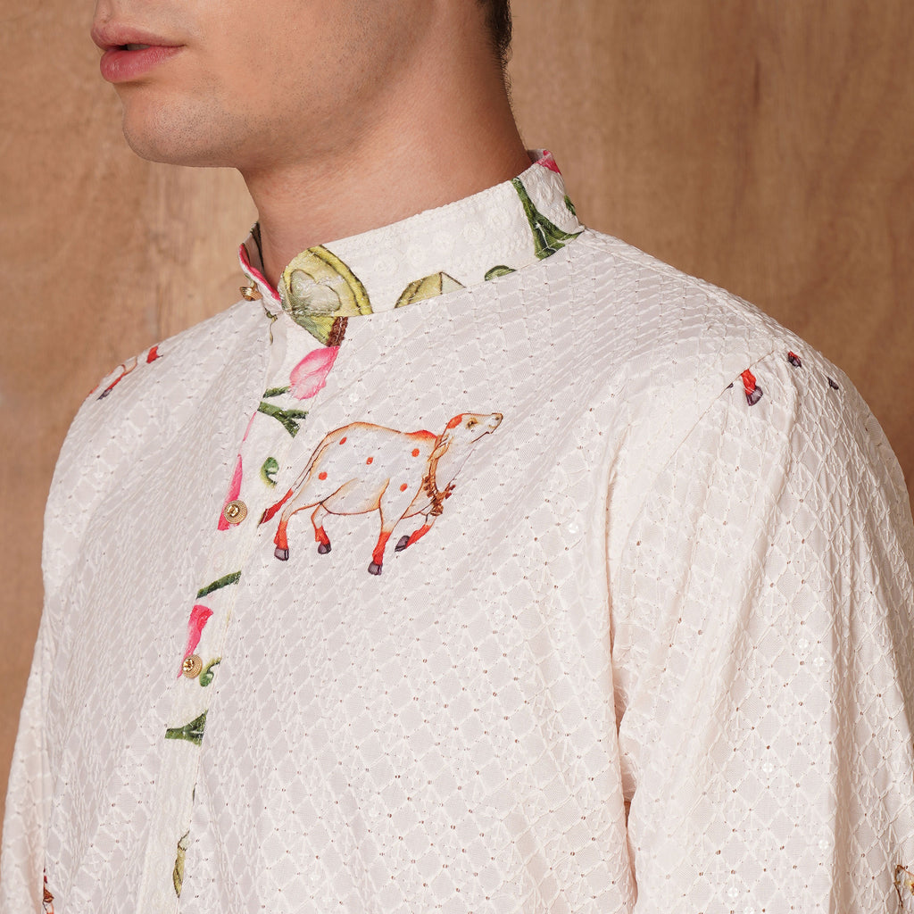 Close-up of collar and shoulder of cream Chikankari Kurta with hand-painted cow and lotus motifs, highlighting fine ethnic detailing.