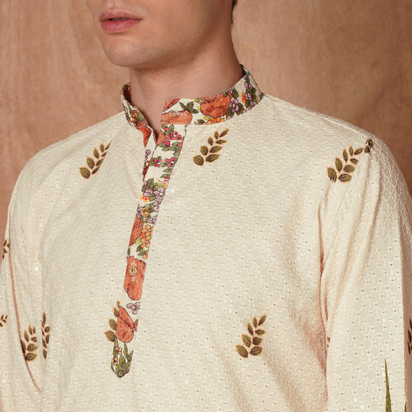Detailed view of kurta collar and placket with floral print accents. Cream Chikankari fabric adds texture and elegance to ethnic wear.