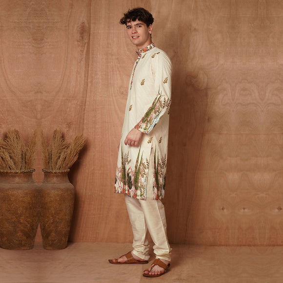 Men's cream Chikankari kurta with side floral detailing and traditional silhouette. Ideal for ethnic gatherings and cultural festivities.