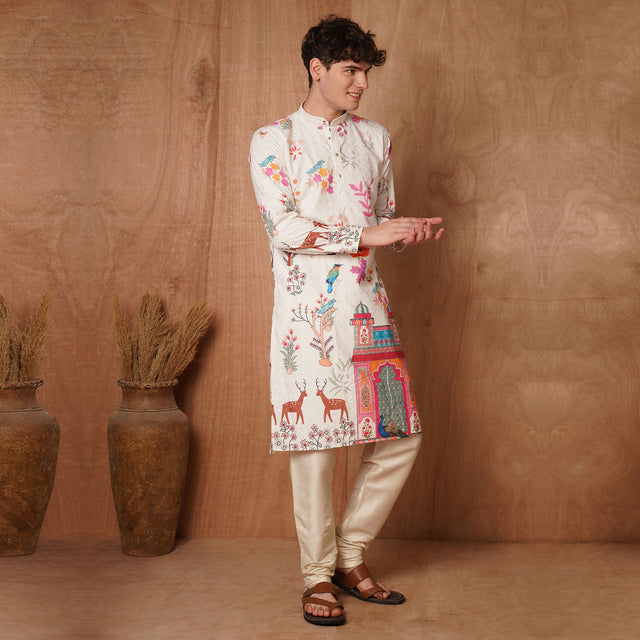 Side pose of model wearing cream Chikankari kurta with colorful Mughal-inspired motifs, ideal for traditional occasions.