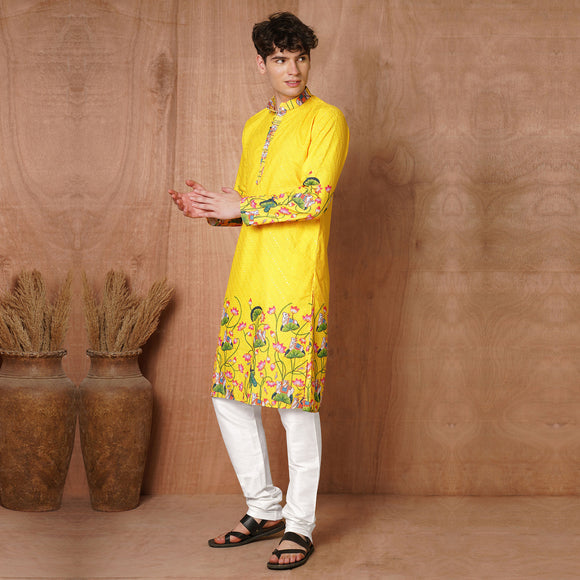 Men’s Yellow Floral Kurta styled with white churidar, perfect for traditional events like Haldi and Diwali.