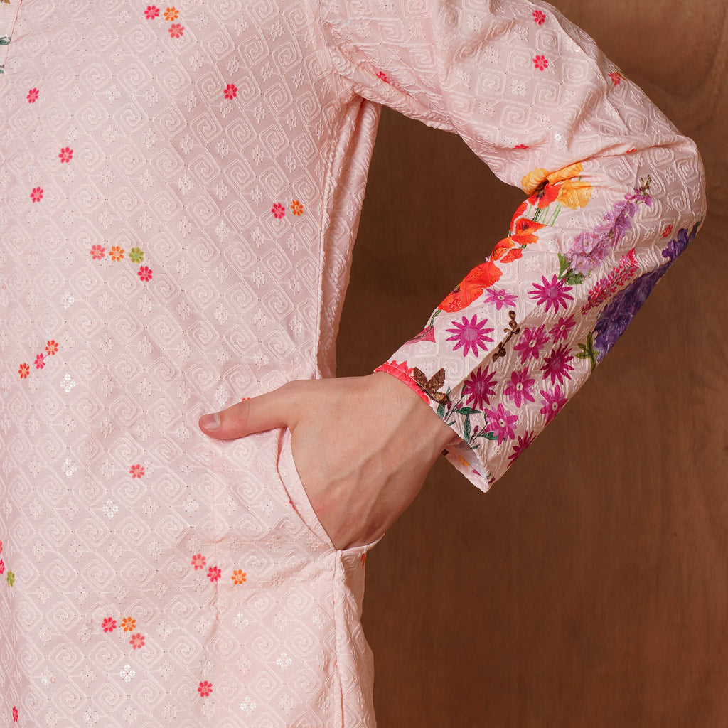 Close-up of pastel pink Chikankari kurta pocket and floral cuff design. Intricate embroidery and botanical accents enhance ethnic elegance.