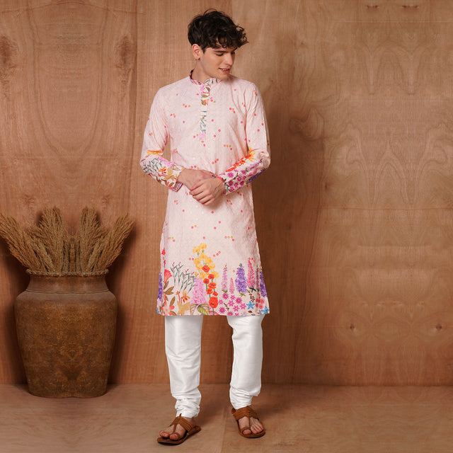 Full view of Men’s Ethnic Pink Chikankari Kurta paired with white churidar. Ideal for weddings and festive occasions with floral hem design.