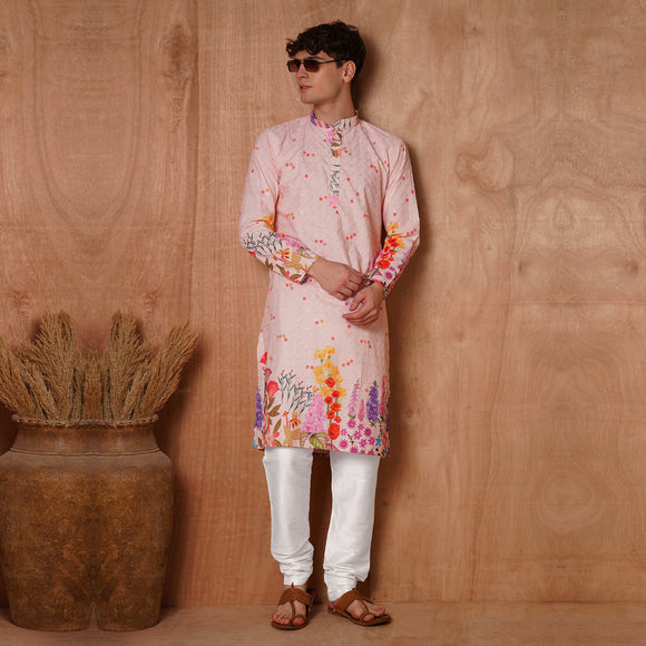 Men’s pastel pink floral kurta with Chikankari embroidery, styled with sunglasses. Fashion-forward ethnic wear for festive and wedding occasions.