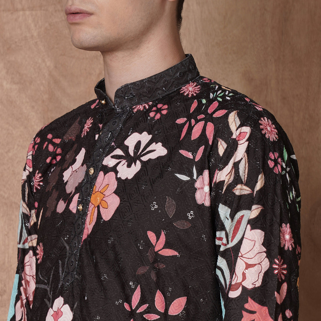 Detailed close-up of collar and floral print on men’s black kurta, highlighting intricate ethnic design for festive occasions.