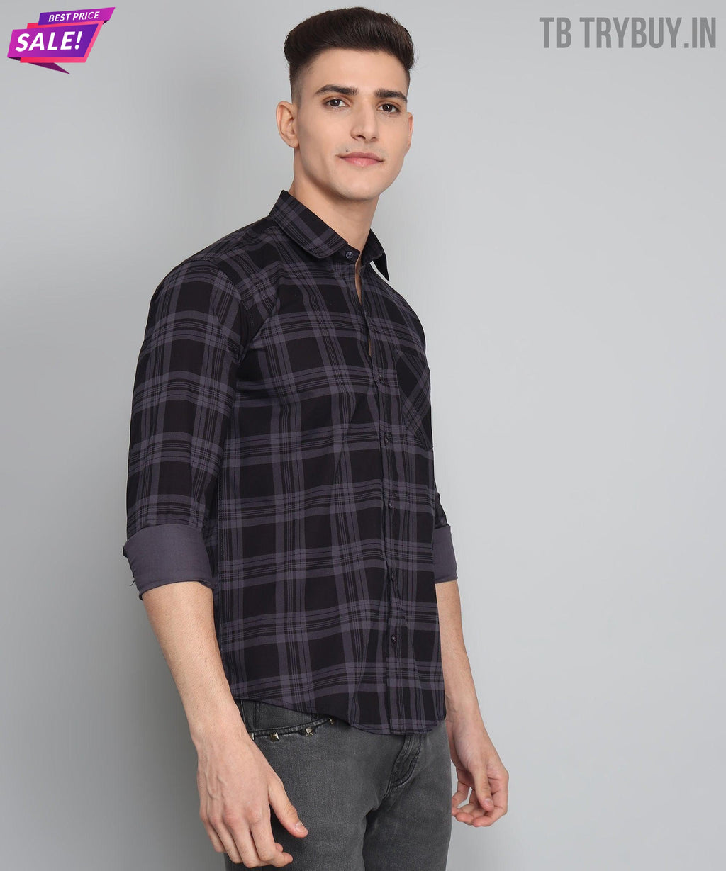 a young man wearing a black and grey plaid shirt