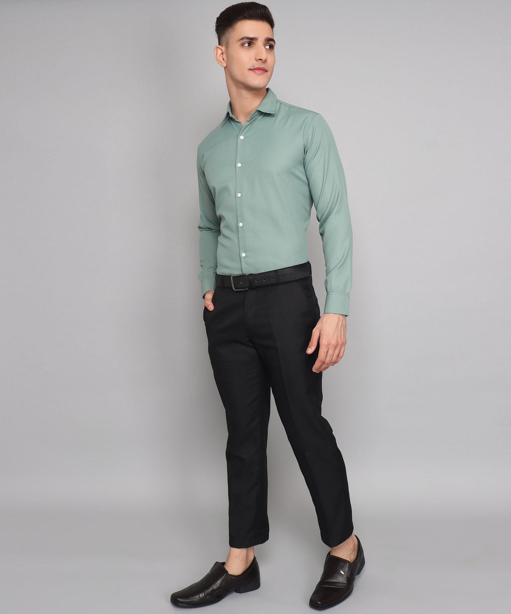 a man in a green shirt and black pants