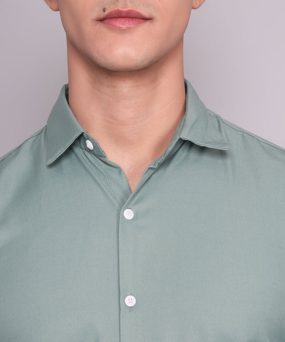 a man wearing a green shirt and glasses