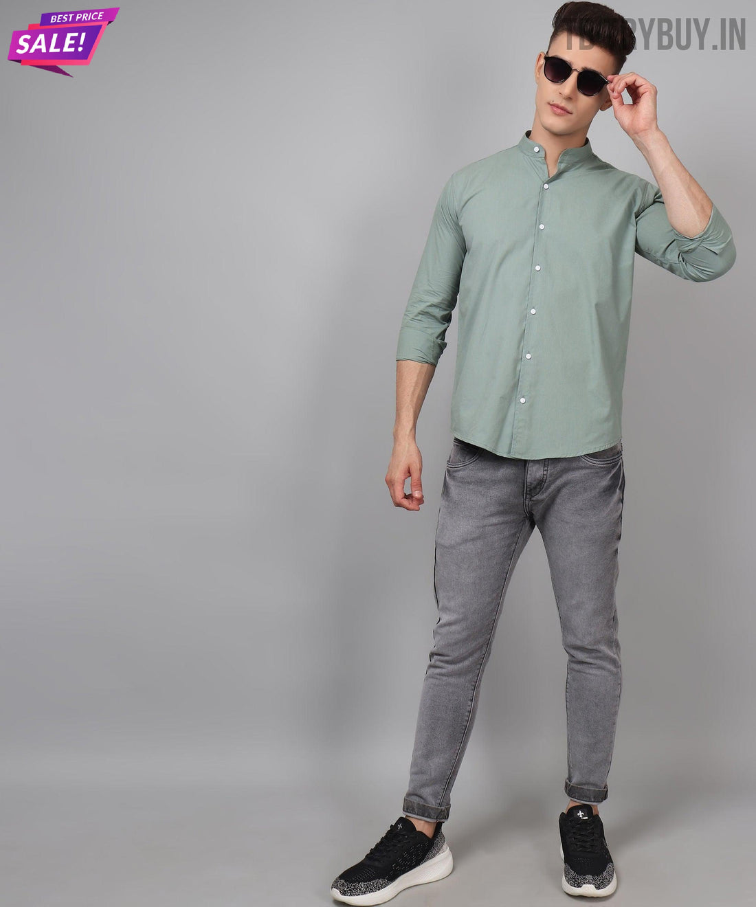 a man in a green shirt and grey pants