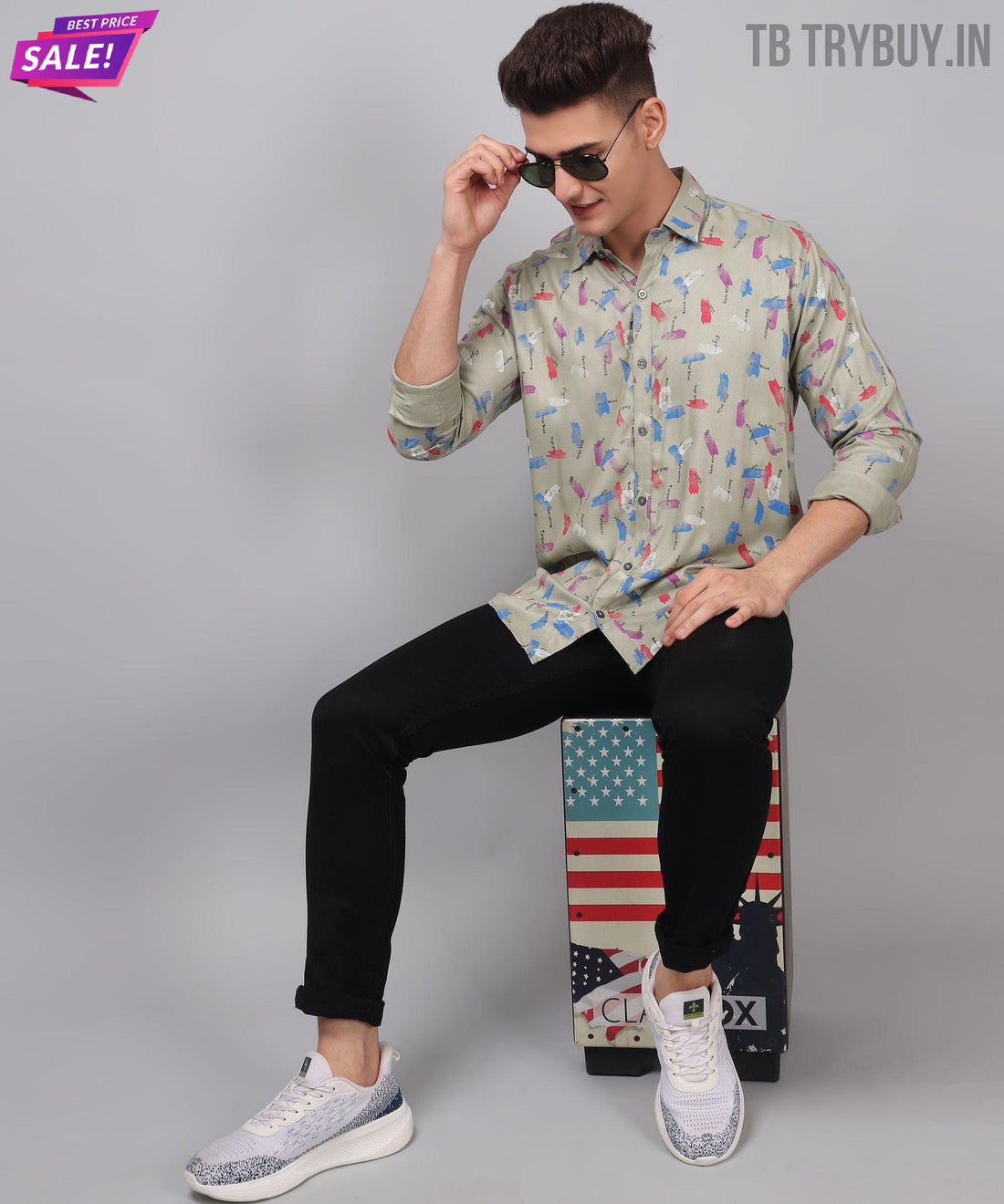 
a man sitting on top of a skateboard wearing sunglasses
