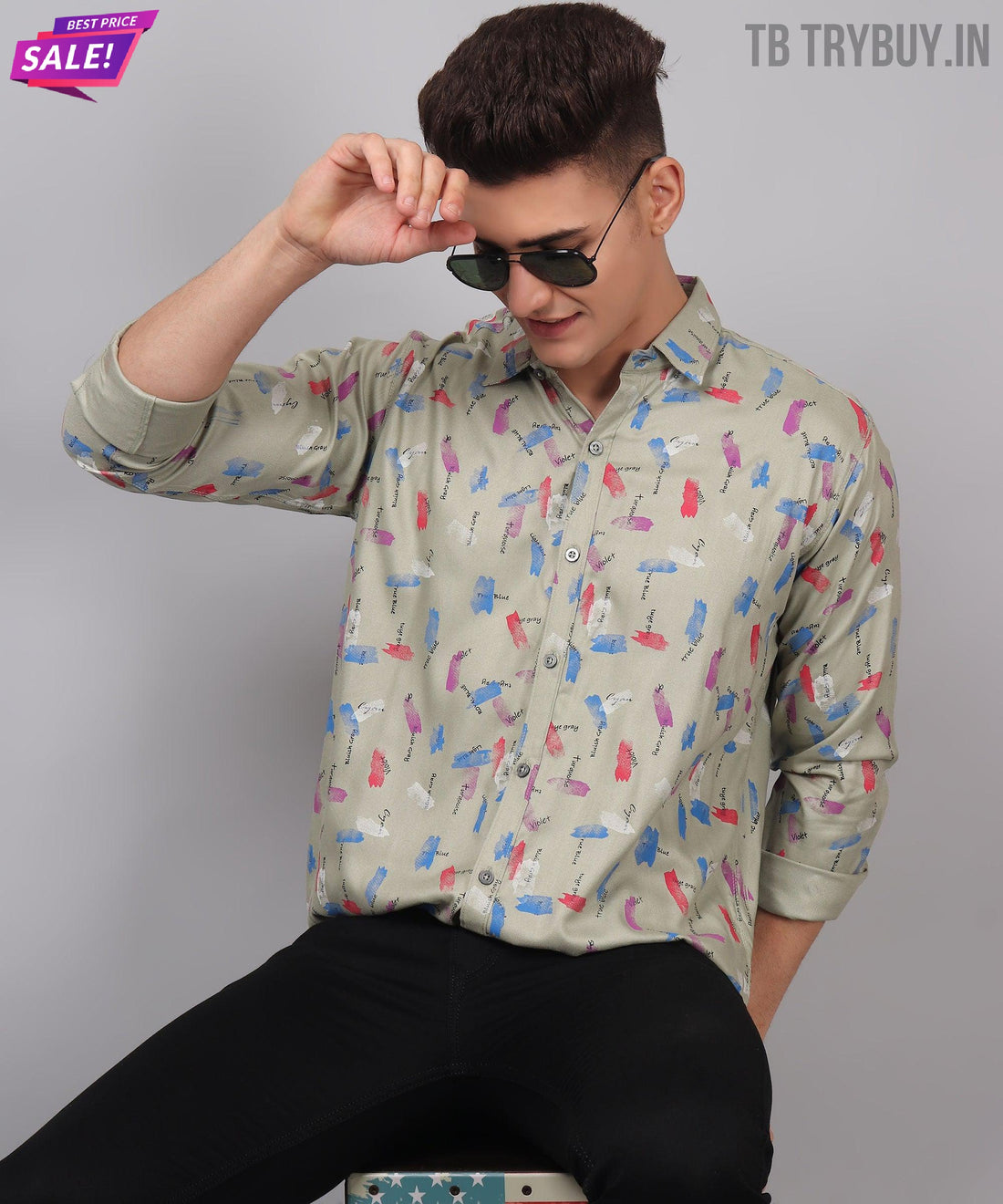 
a man sitting on a stool wearing sunglasses
