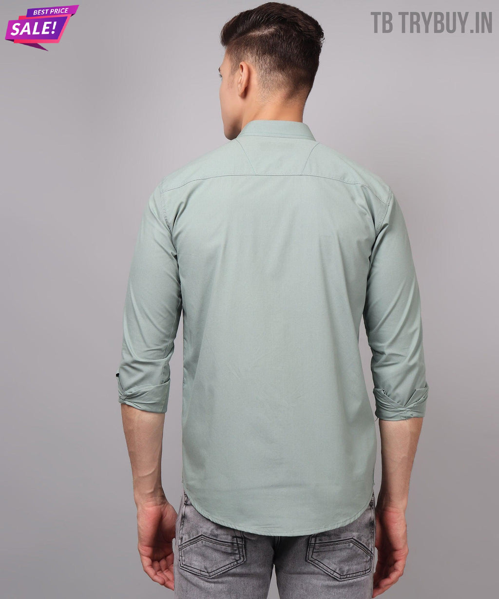 a man wearing a light green shirt and jeans