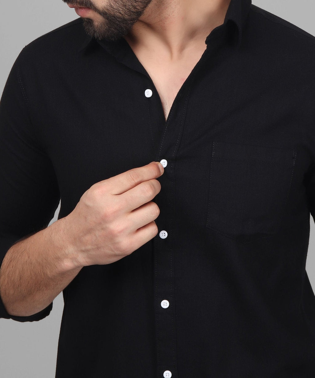 a man wearing a black shirt with white buttons