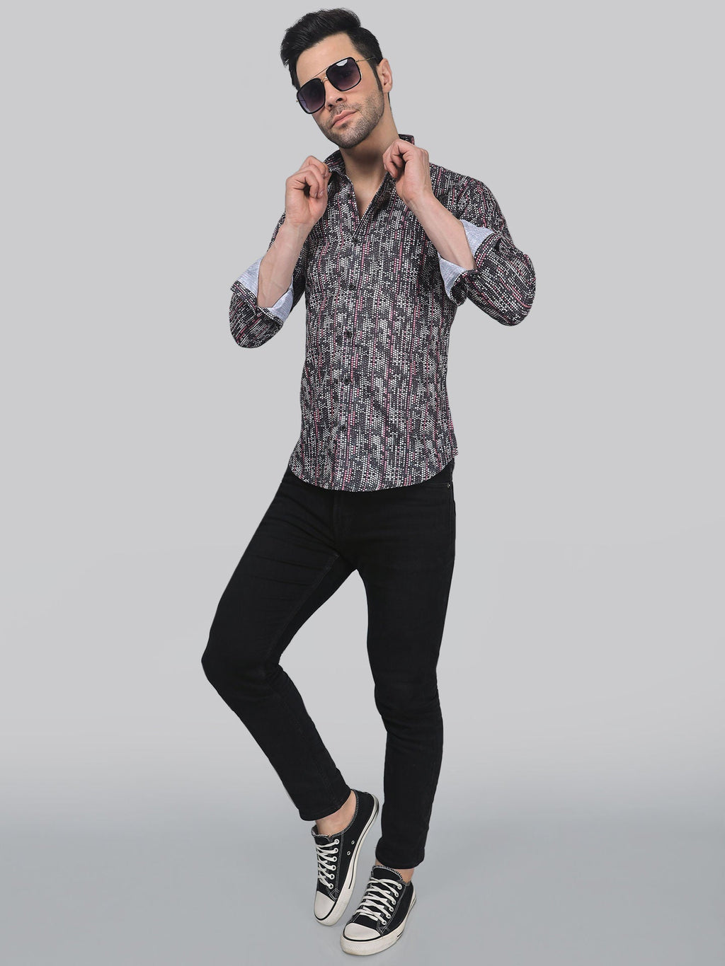 a man in a shirt and black pants posing for a picture