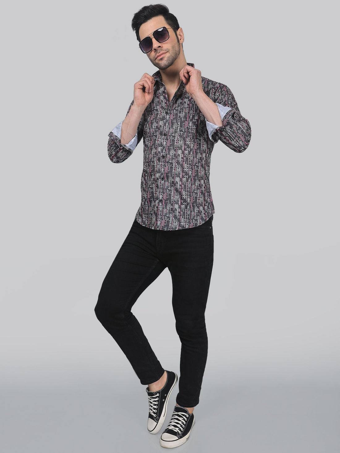 
a man in a shirt and black pants posing for a picture
